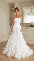 Front view of ivory strapless mermaid gown with pleated skirt and dramatic ruffle hem