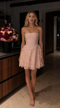 Front full view of pink strapless lace mini dress