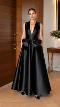 Front view of black sleeveless deep V satin-look ball gown with oversized waist detail