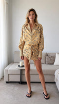 Model wearing yellow boho printed long sleeve shirt and shorts set, front view