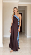 Front view of woman wearing brown one-shoulder satin maxi dress with blue lace applique