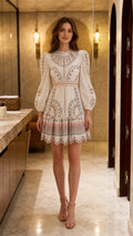 Front view of model wearing white embroidered mini dress