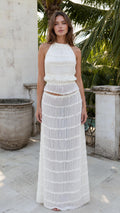 Front view of woman wearing white textured halter crop top and maxi skirt set