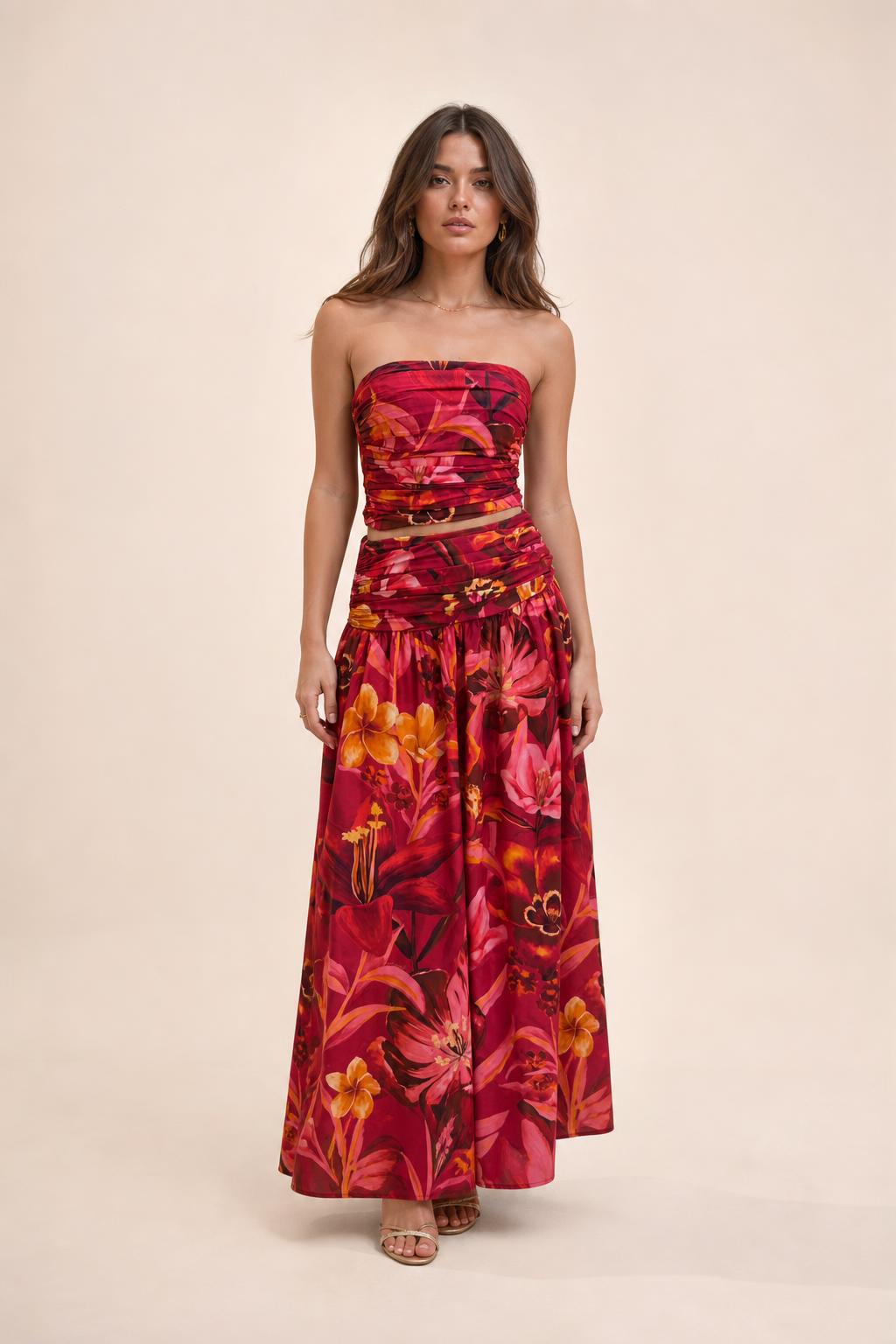 Model wearing red floral strapless crop top and maxi skirt set front view