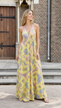 Model wearing yellow floral halter maxi dress from the front