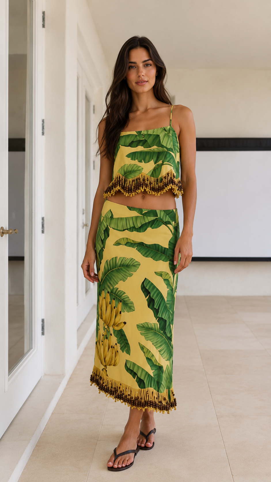 Front view of yellow tropical print cami top and maxi skirt set with fringe trim