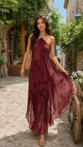 Woman wearing a wine halter maxi dress with layered ruffle hem