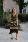Model wearing black vintage gold print sleeveless midi dress front view