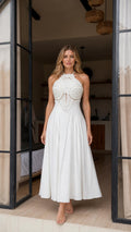 Front view of model wearing white halter neck beaded maxi dress
