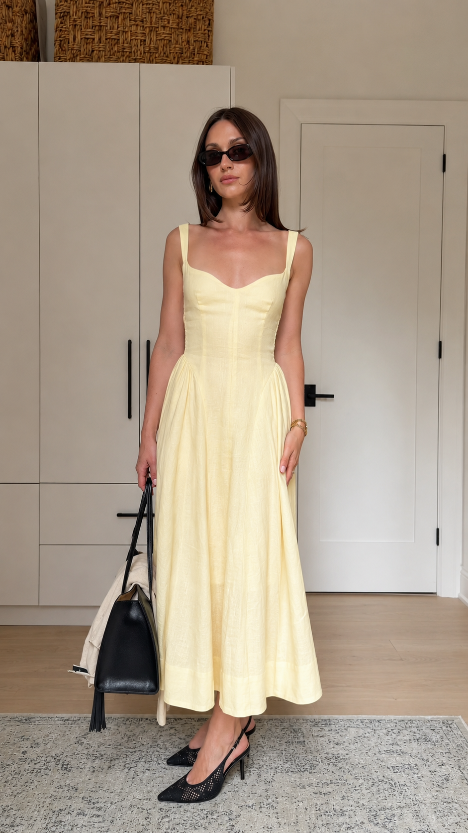Model wearing a butter yellow sleeveless sweetheart neck midi dress with a fitted bodice and flared skirt