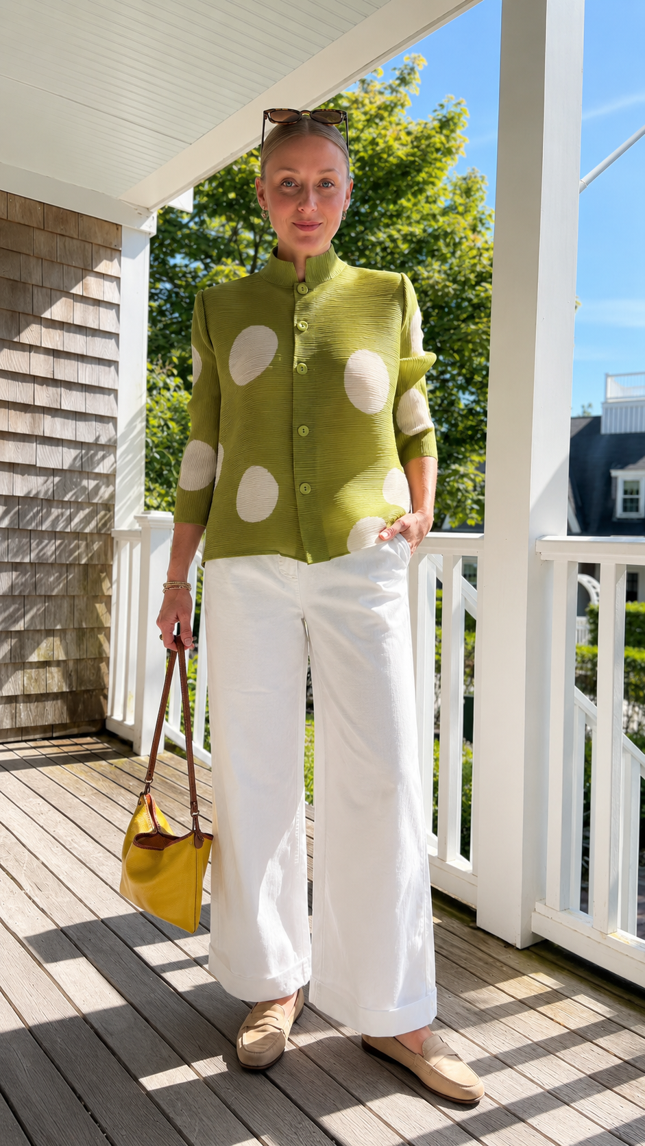 Front view of olive green pleated polka dot button-front jacket top with white wide-leg pants