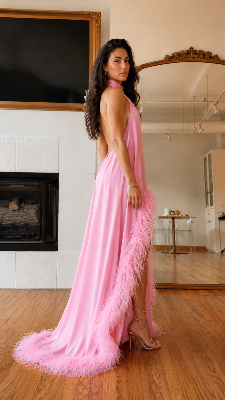 Side view of pink open-back halter maxi dress with feather trim