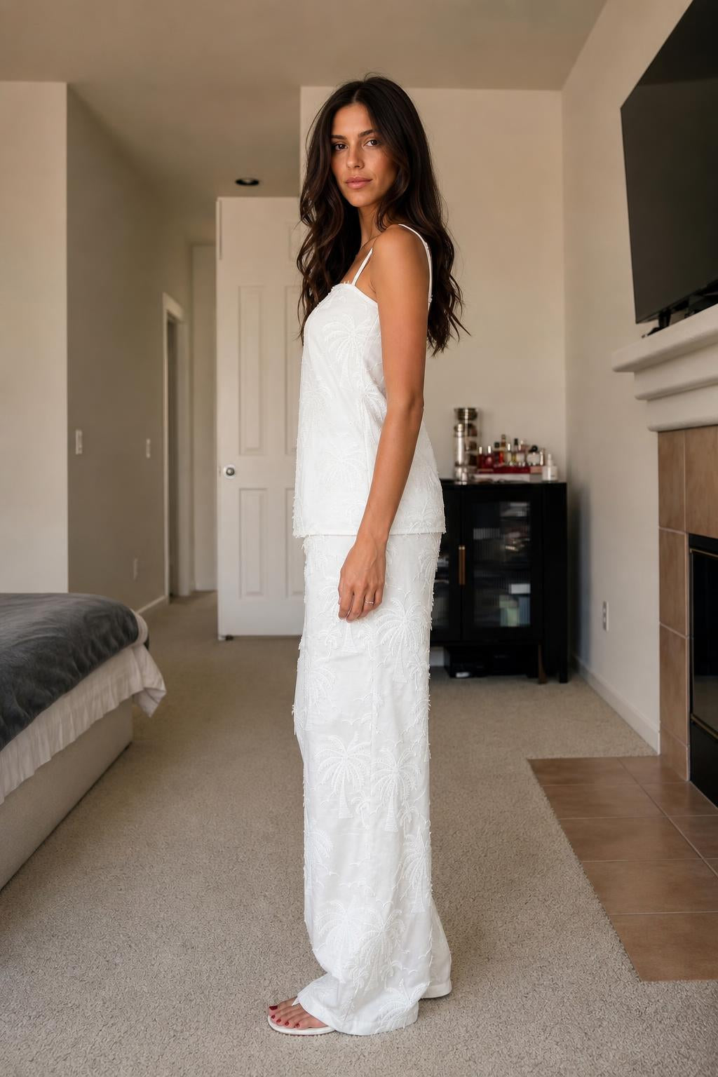 Side view of woman in white palm embroidered two-piece set