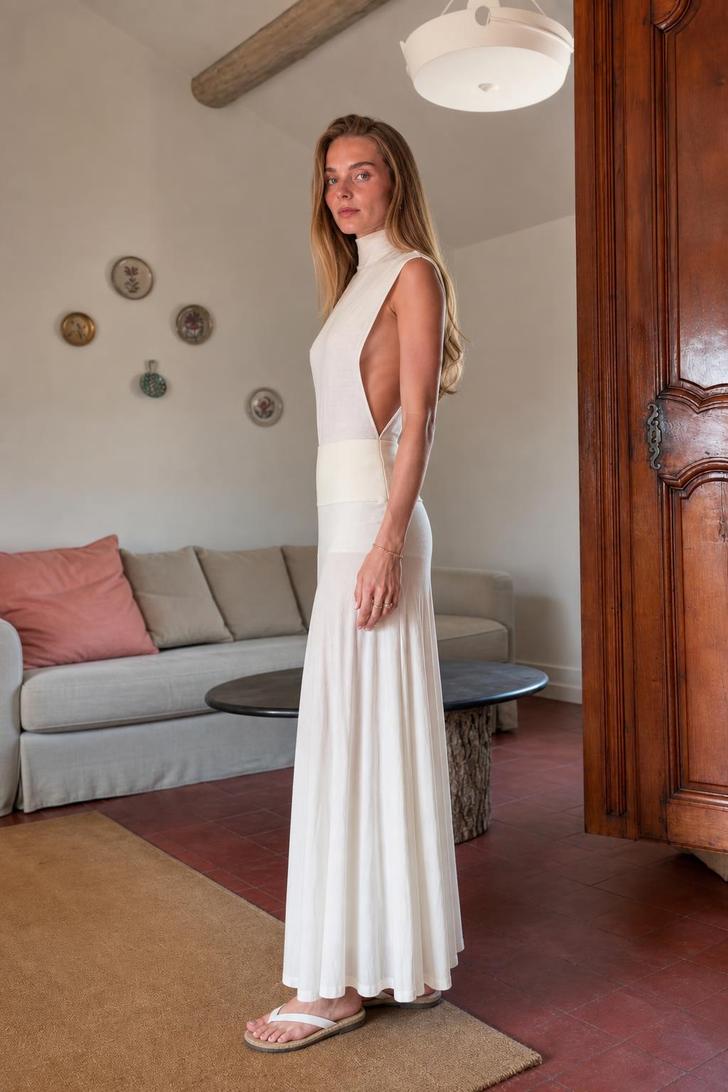 Side profile view of white knit maxi dress showing silhouette