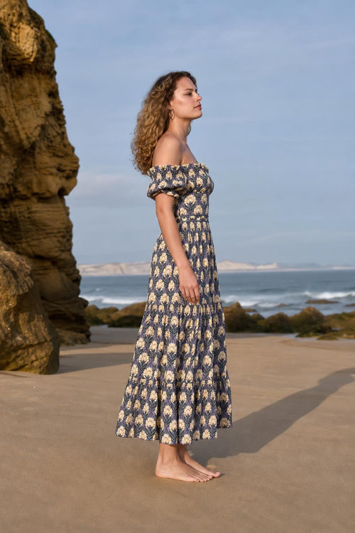 Side profile view of woman in blue floral midi dress