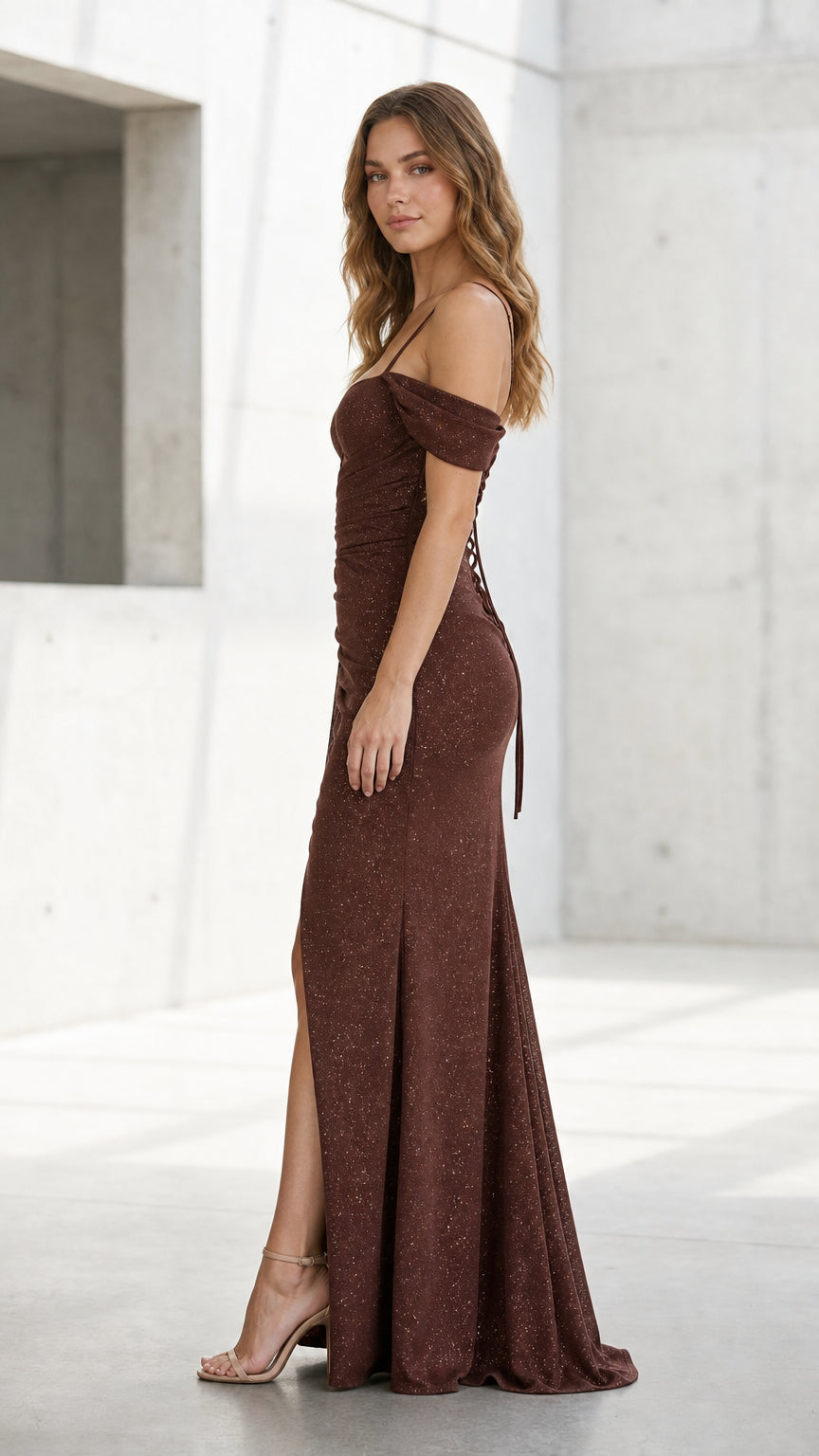 Side profile view of brown evening dress showing silhouette and floor-length hem