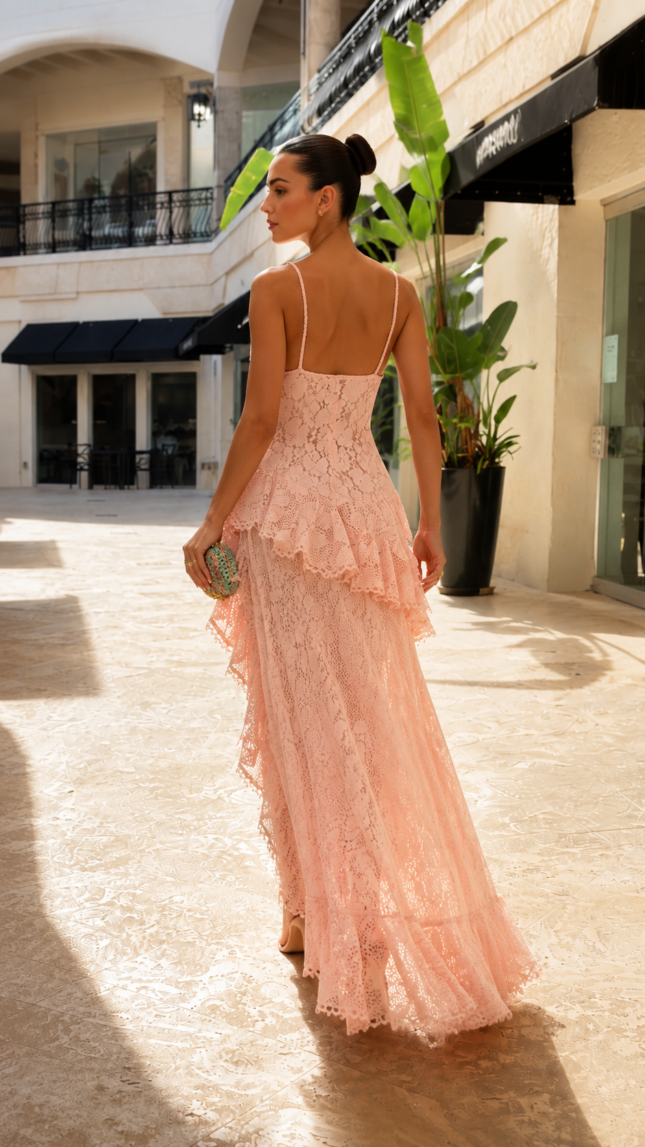 Back view of blush pink lace maxi dress with slim straps and flowing asymmetric hem