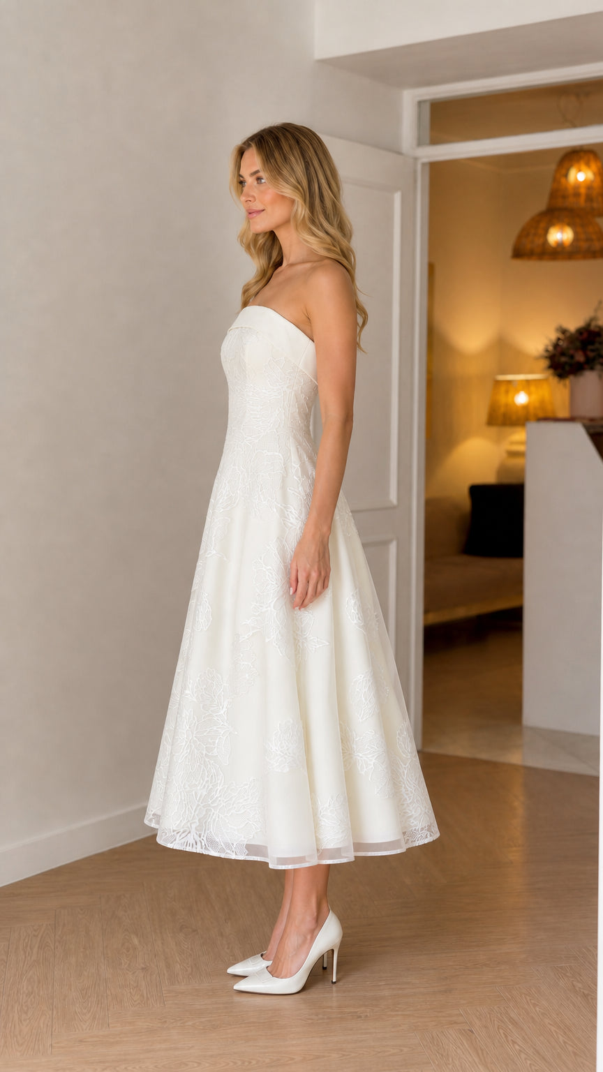 Side profile of model in white strapless midi dress with heels