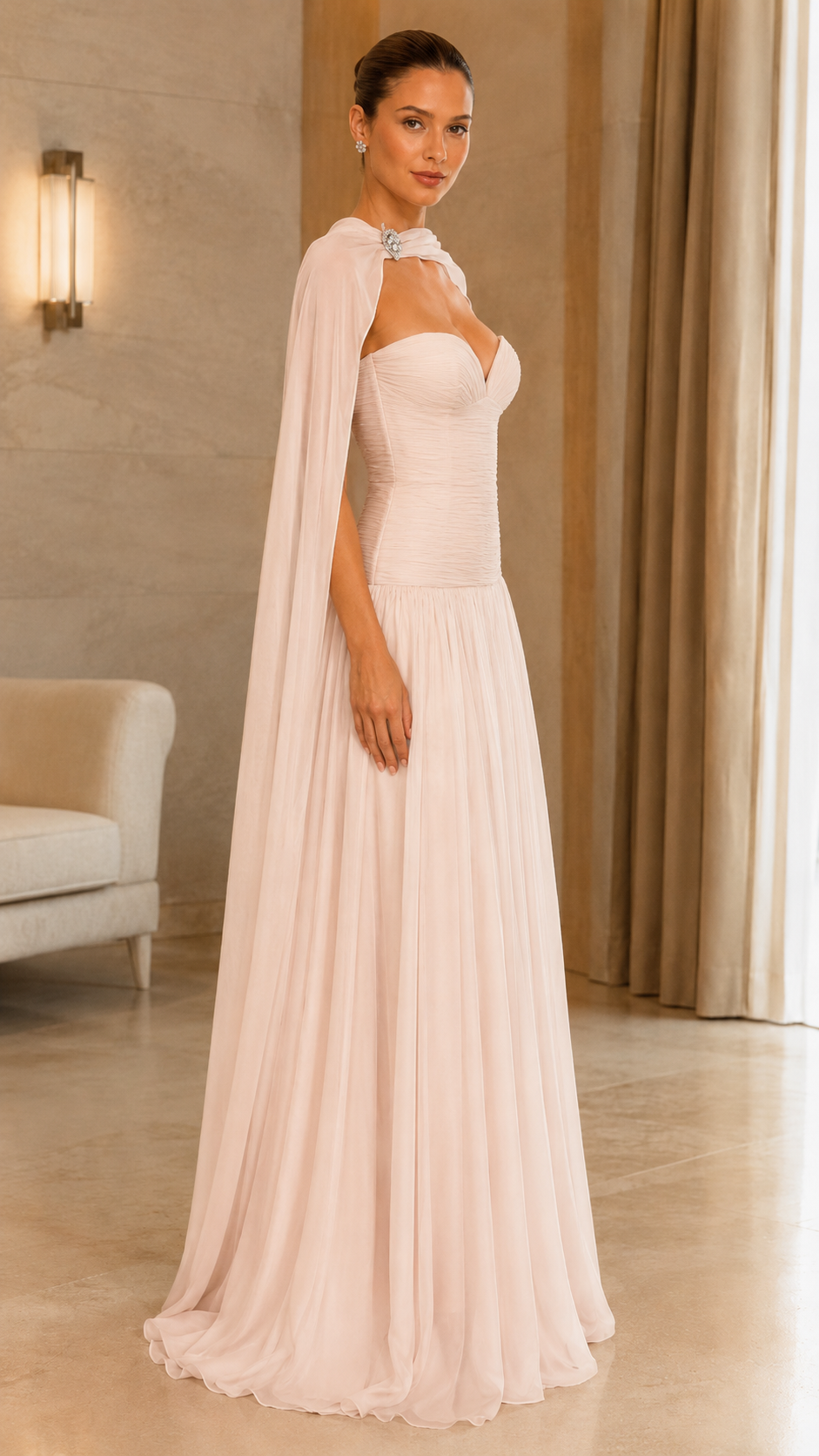 Side view of blush formal gown with shoulder cape and floor-length drape