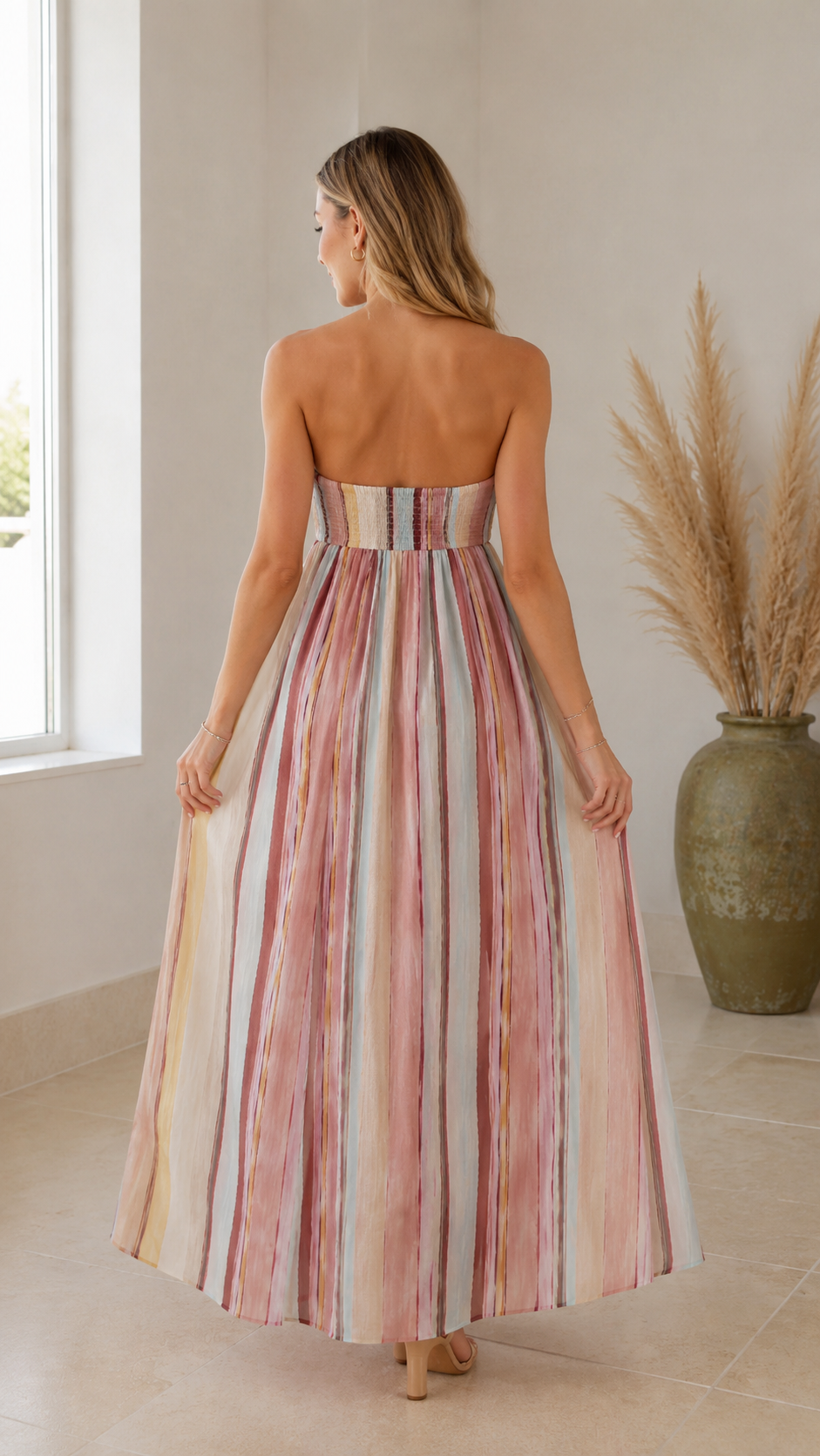 Back view of multicolor striped strapless maxi dress with flowing full-length skirt