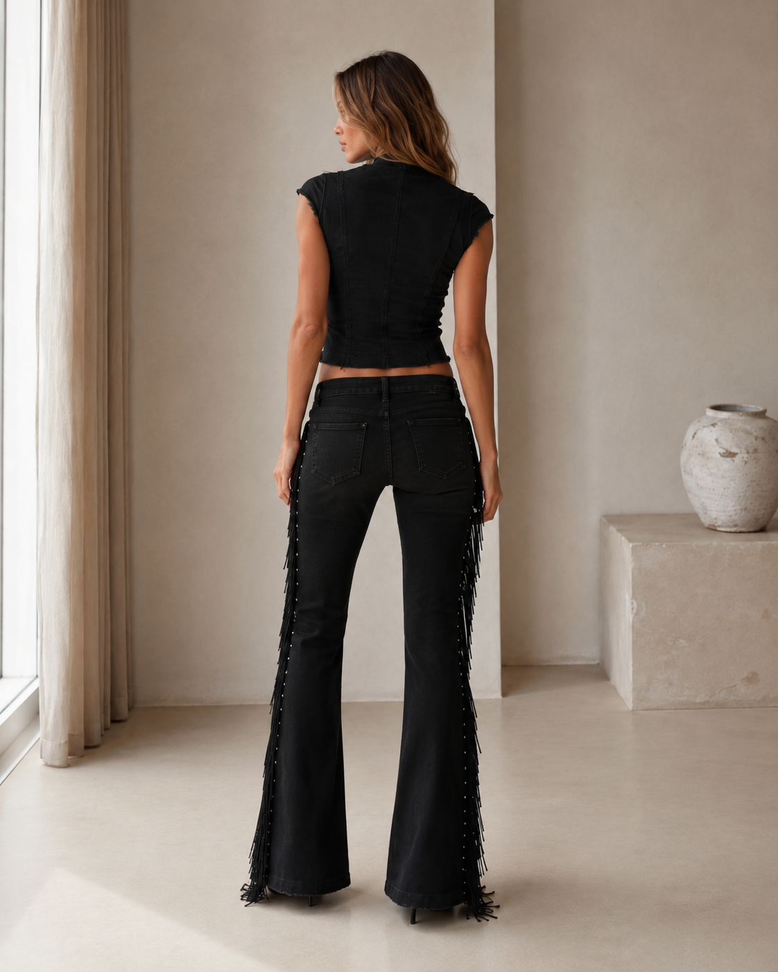 Back view of the black matching set with fitted cap-sleeve top and fringe flare pants