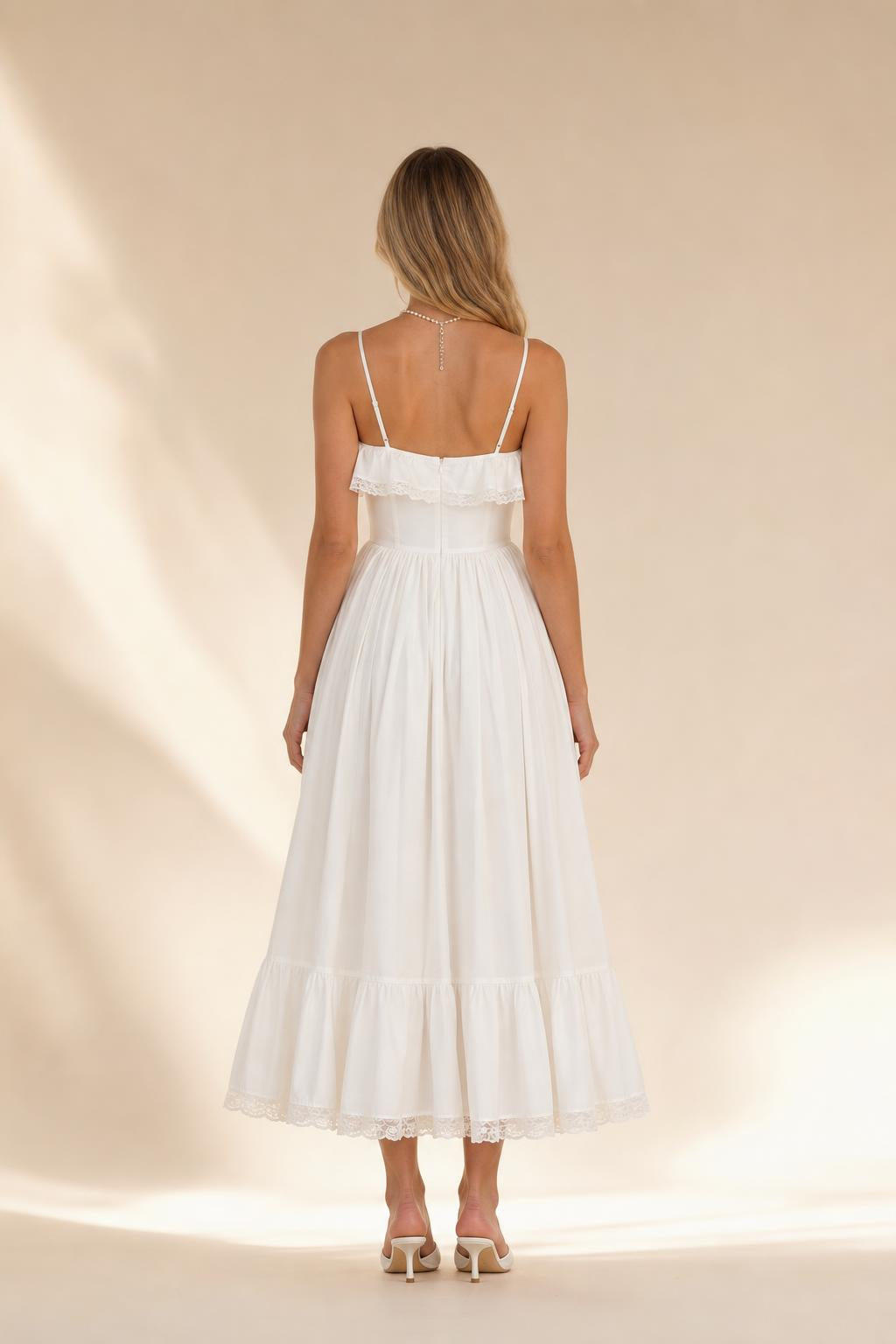 Back view of woman wearing white tiered midi dress