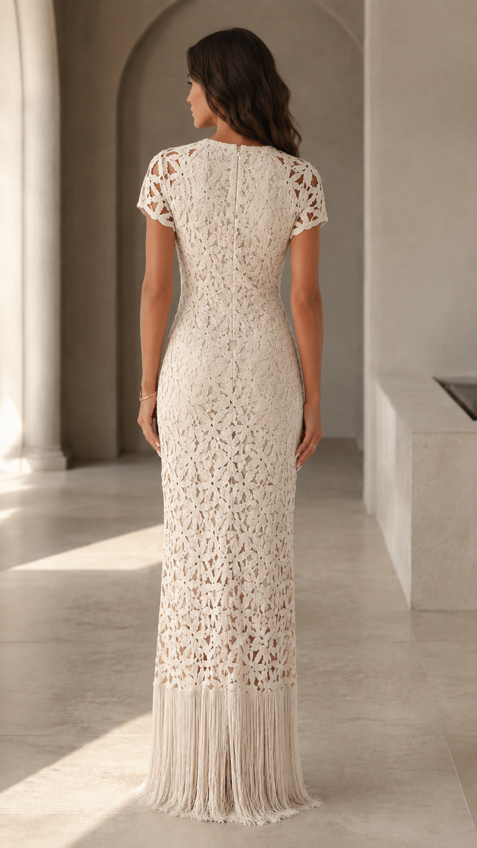 Back view of cream short sleeve crochet-look maxi dress with floor-length fringe hem
