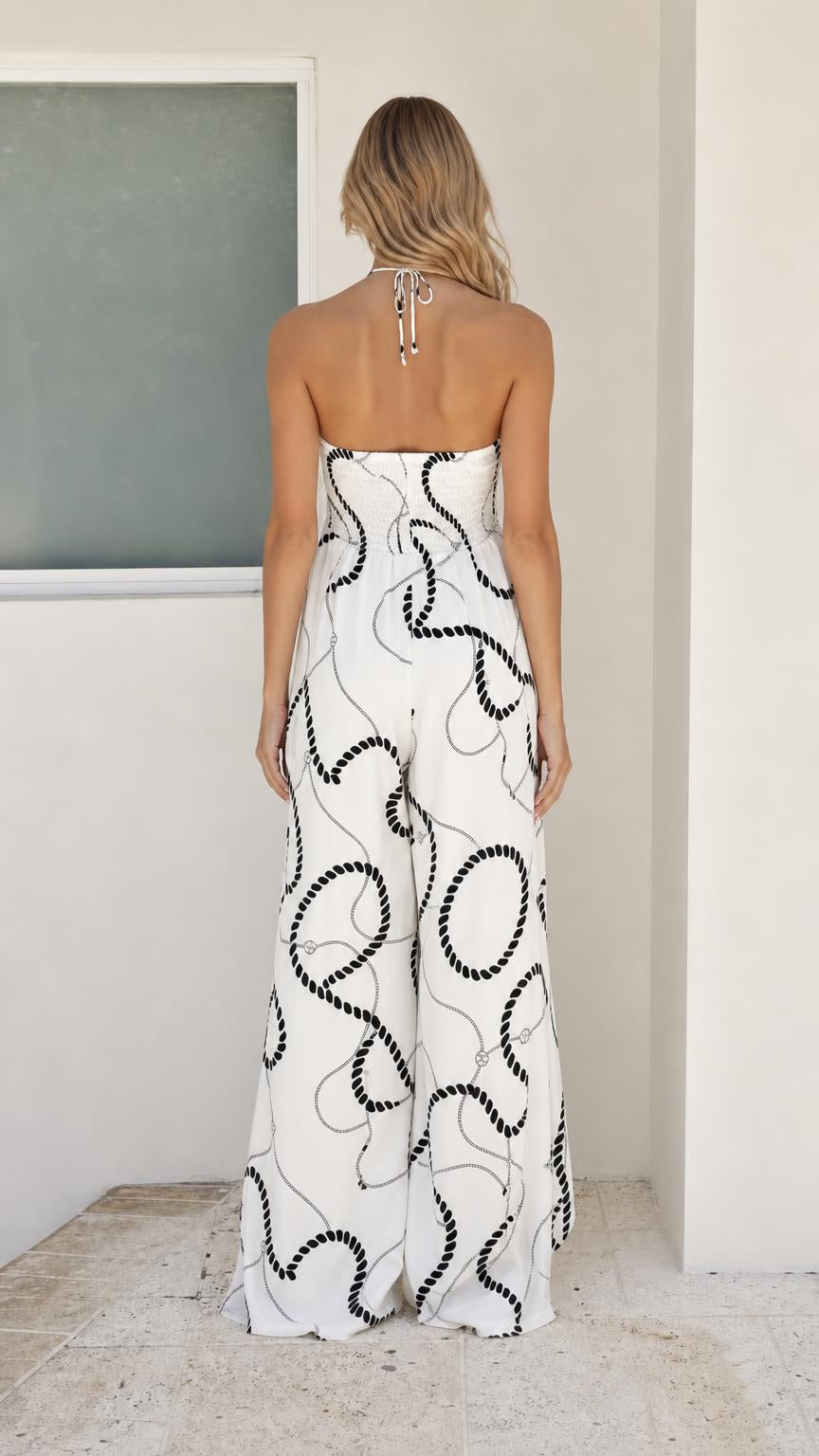 Back view of white rope print halter jumpsuit showing open back