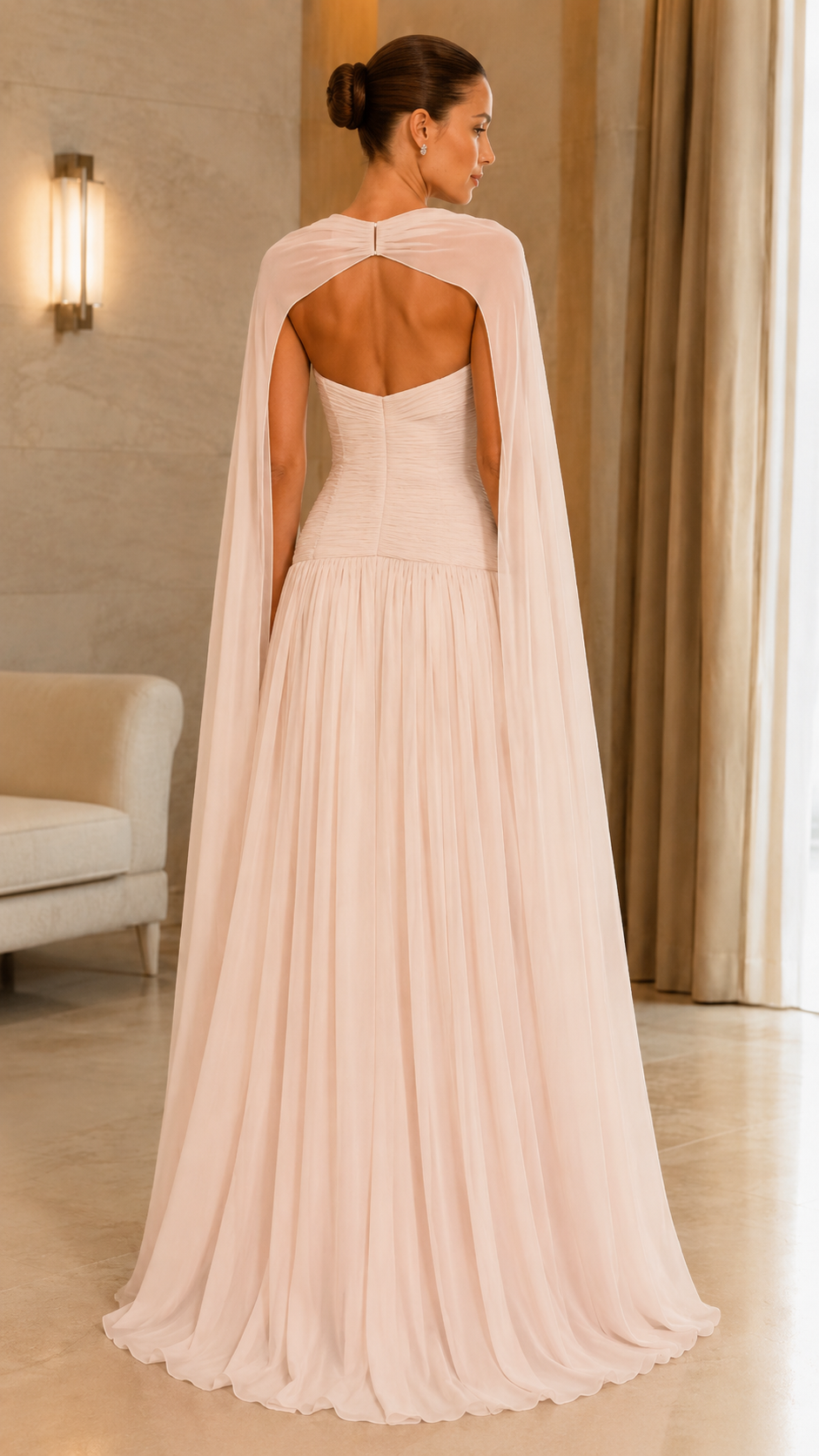 Back view of blush cape gown with open upper back and gathered full skirt