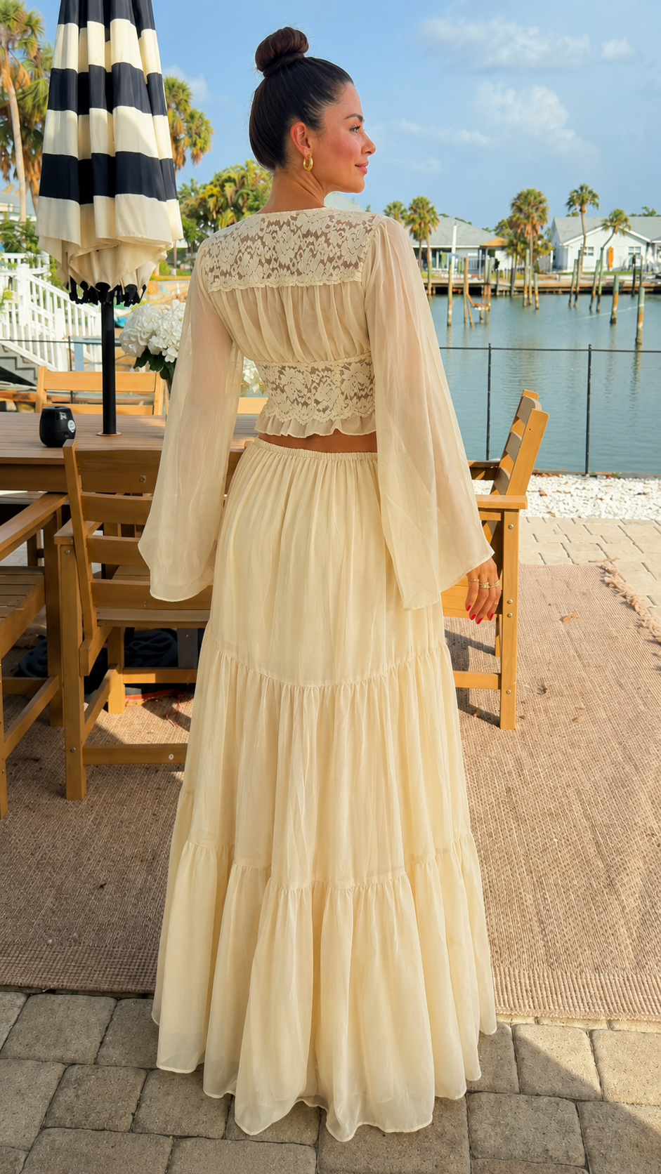 Back view of cream two-piece maxi skirt set showing lace back detail and tiered skirt