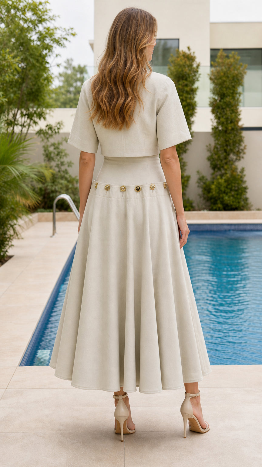 Back view of woman wearing beige crop top and flared midi skirt