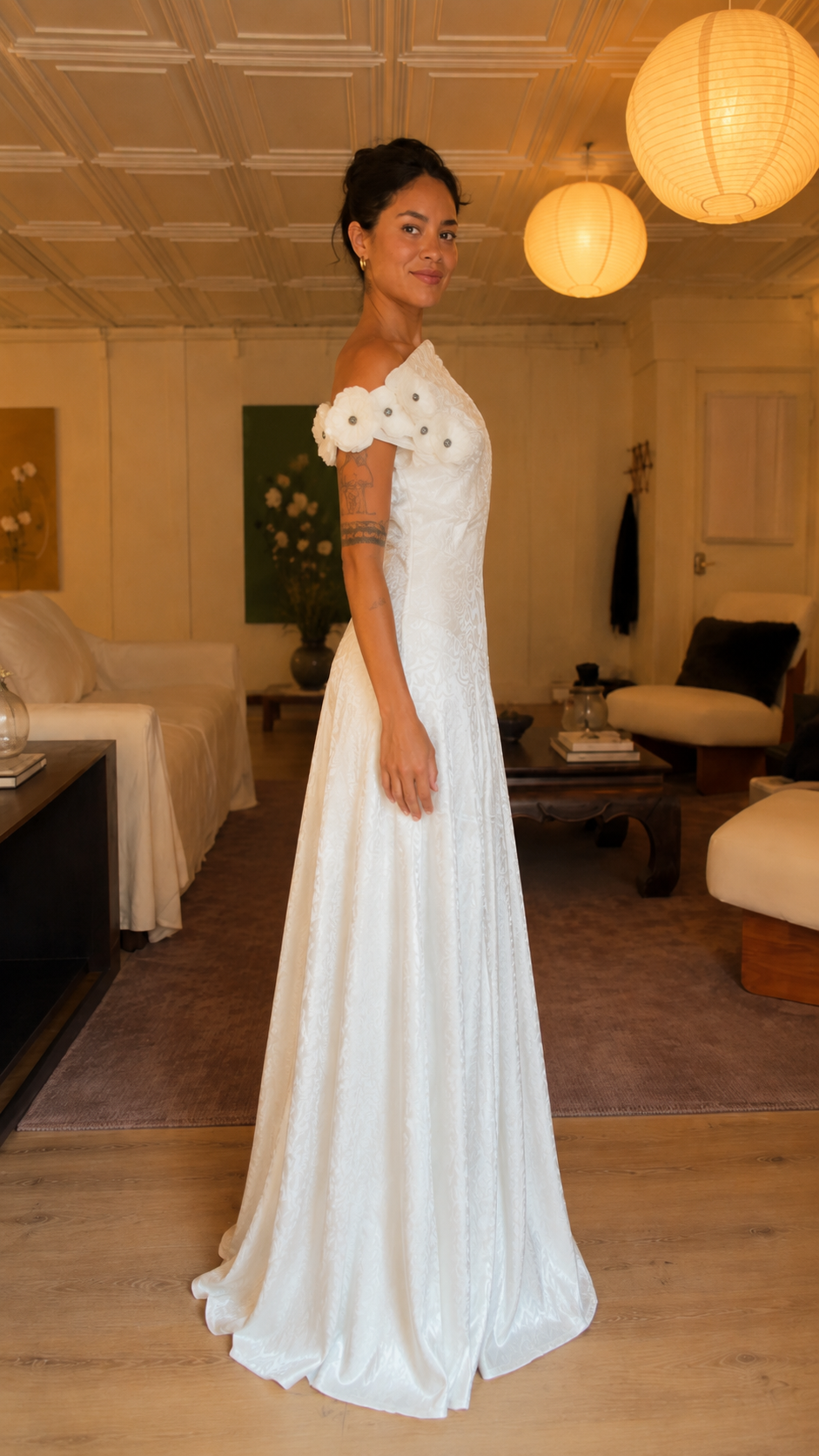 Side view of white one-shoulder formal gown with floral shoulder detail