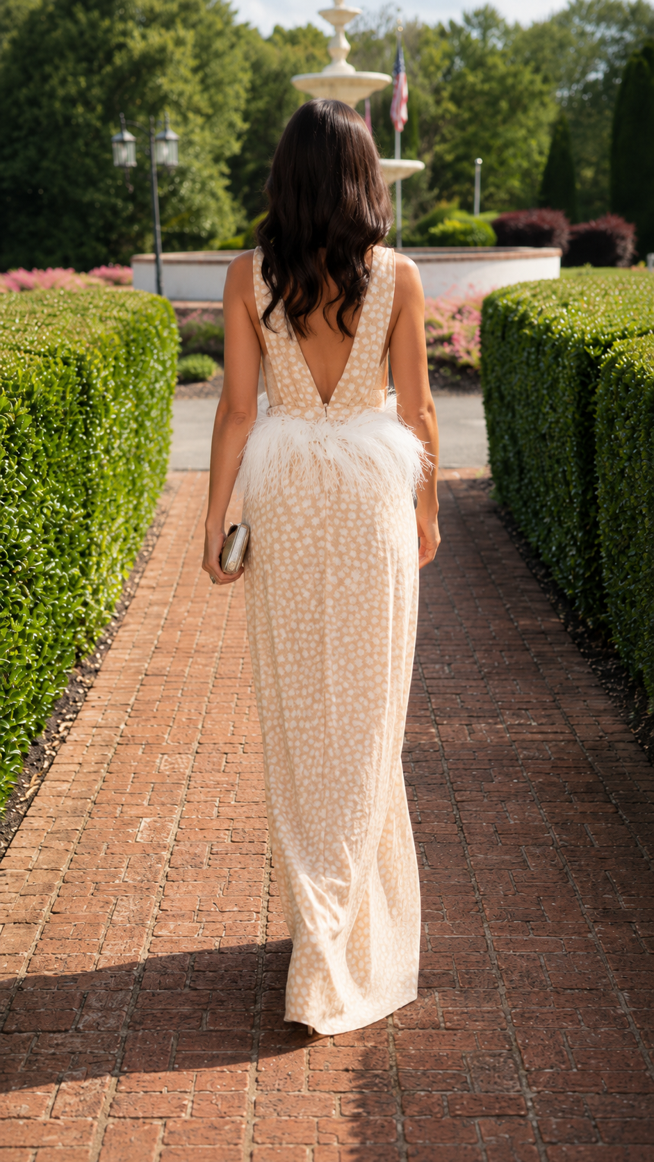 Back view of champagne wide leg jumpsuit with deep V open back and feather-look waist trim