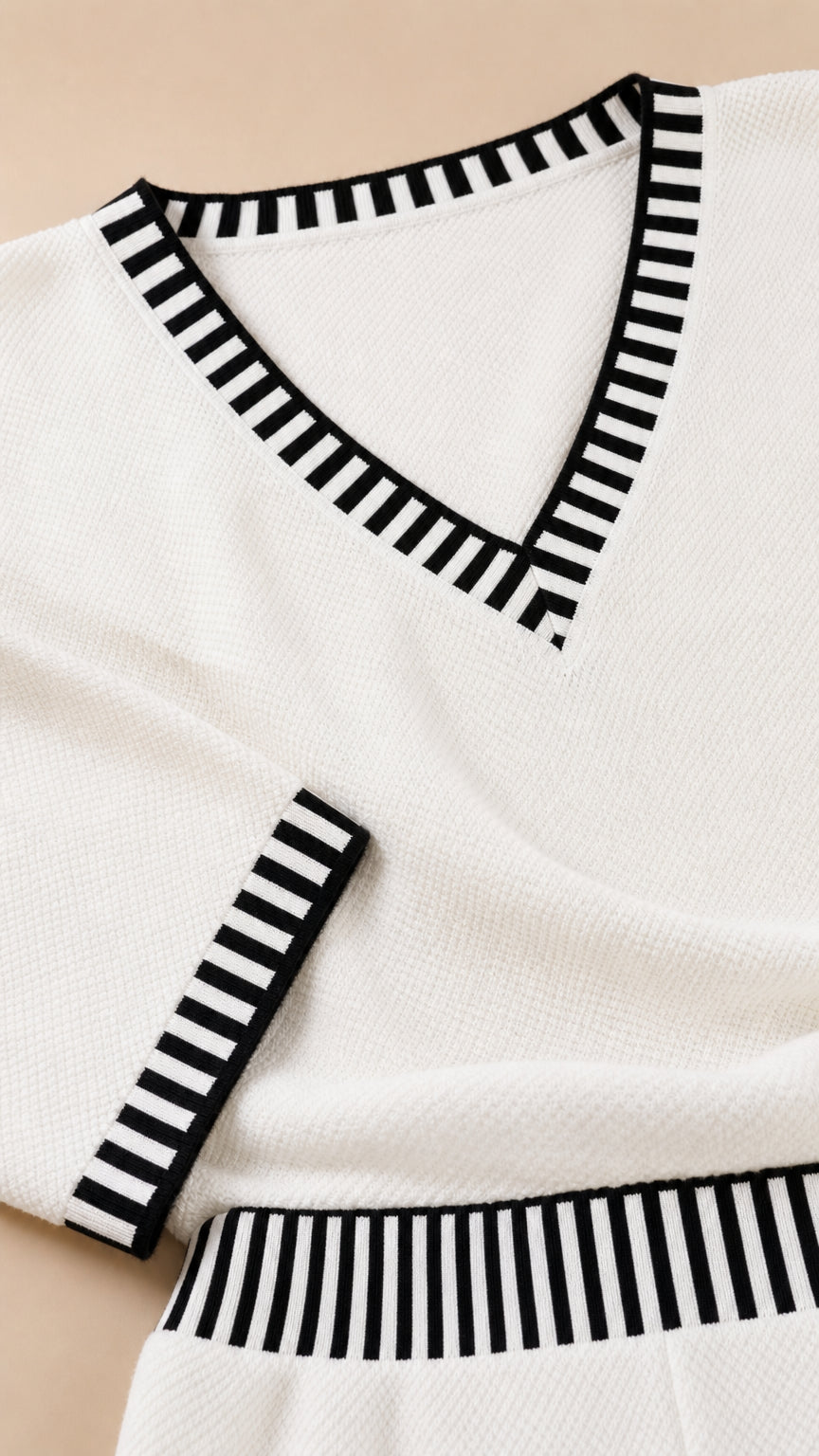 Close up detail of black and white striped trim on V-neck collar and cuffs