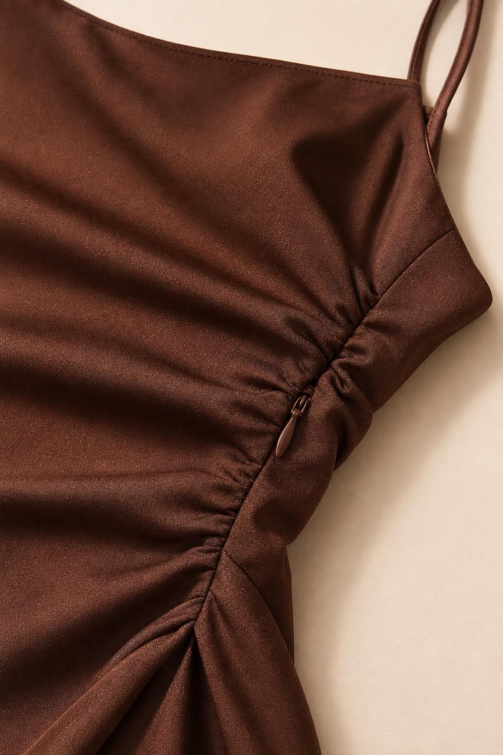 Close-up detail of side ruching and zipper on brown satin dress