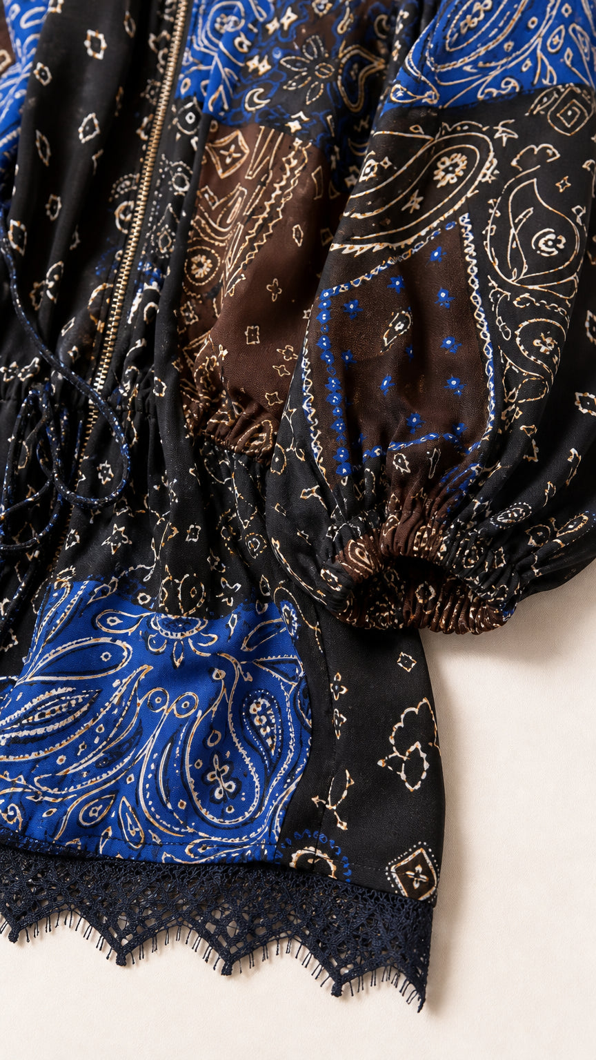Close-up detail of paisley fabric print, zipper, and lace hem