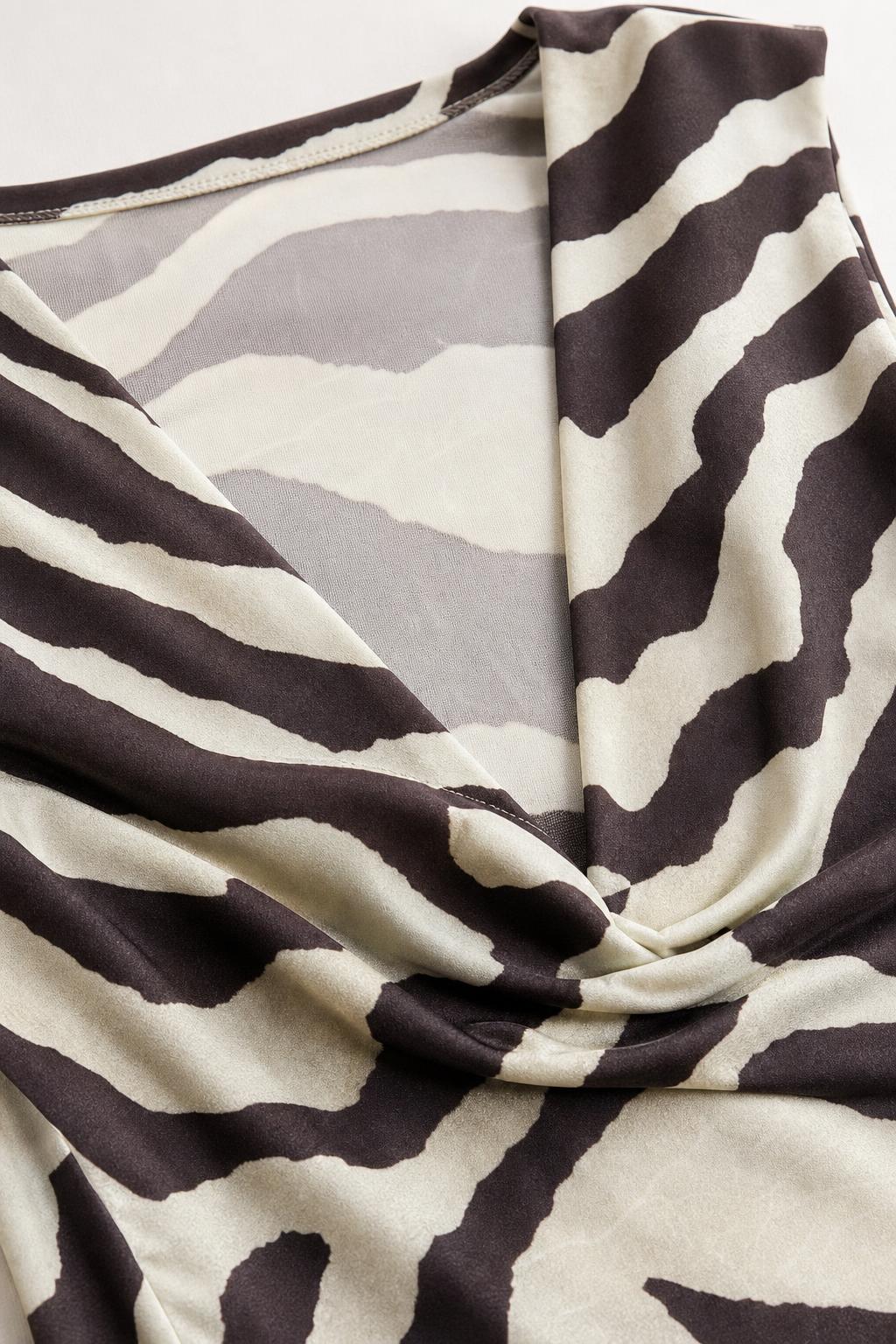 Close-up detail of the cowl neck and smooth fabric