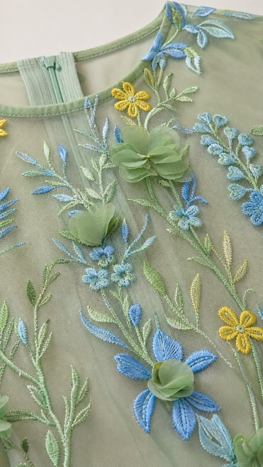 Close-up of embroidery and 3D flower details on sage green dress