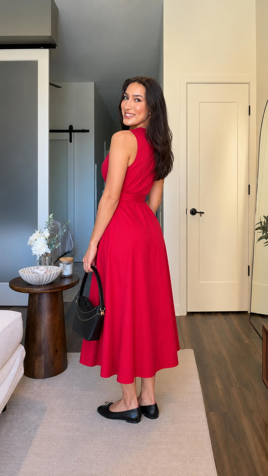 Back angle of red sleeveless midi dress showing defined waist and full hem