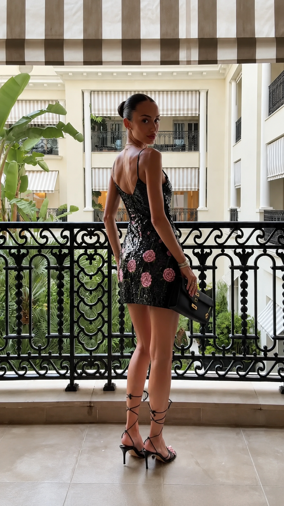 Back view of black sequin floral mini dress with low back