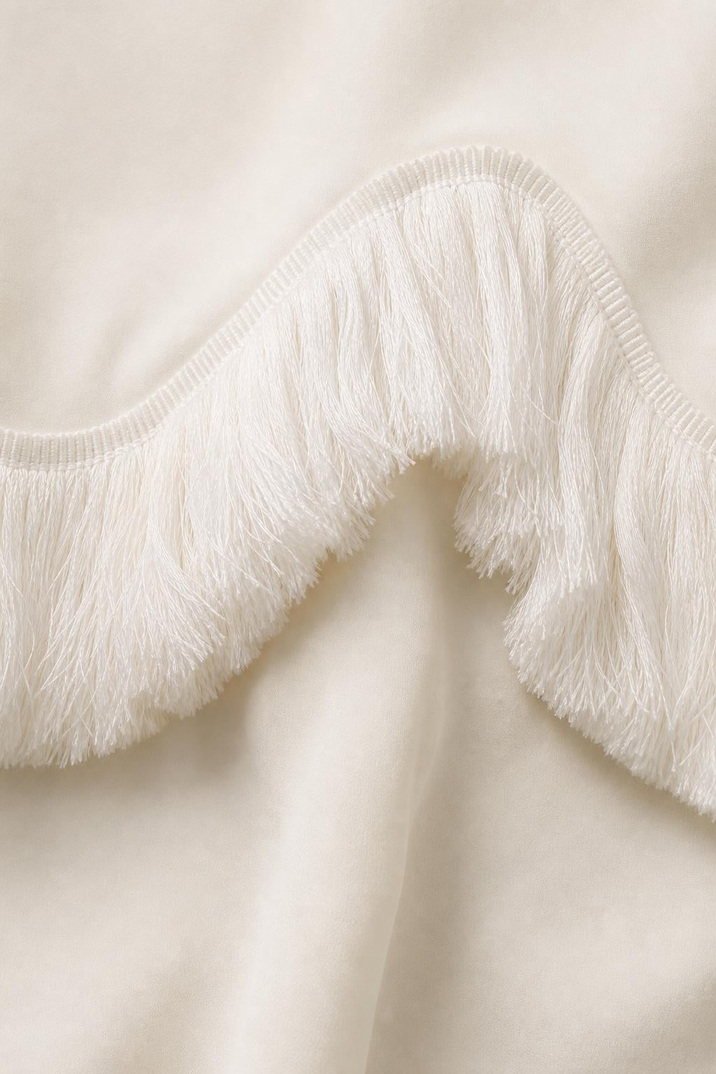 Close-up detail of white fringe trim on fabric