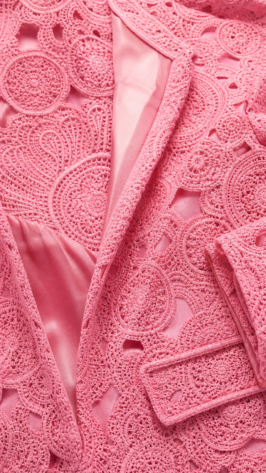 Close-up detail of pink textured lace fabric and satin lining