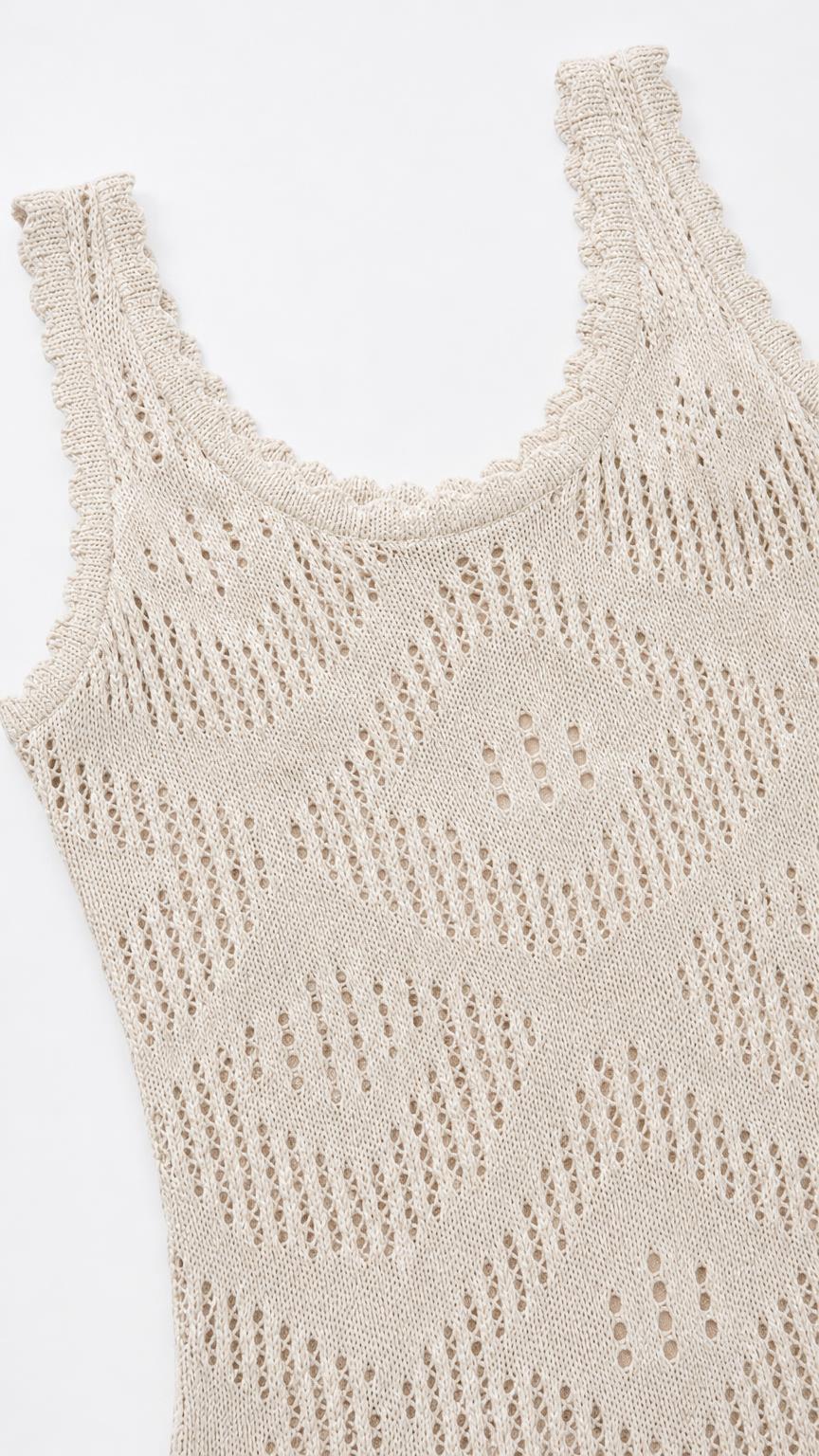 Close-up detail of neckline and open knit pattern on beige dress