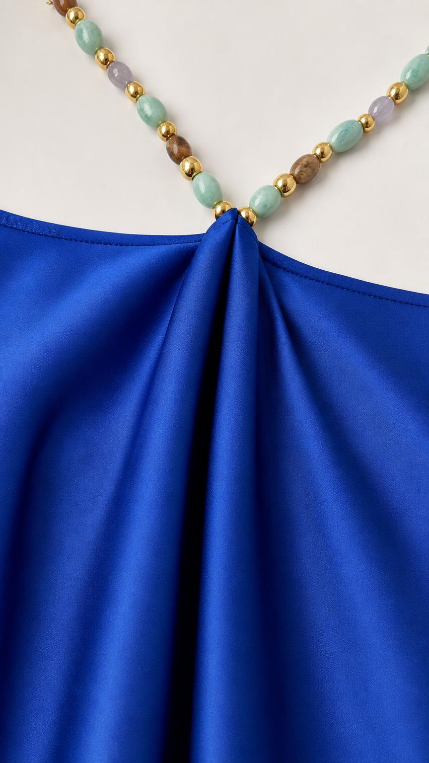 Close-up detail of multi-colored beaded hardware on dress strap