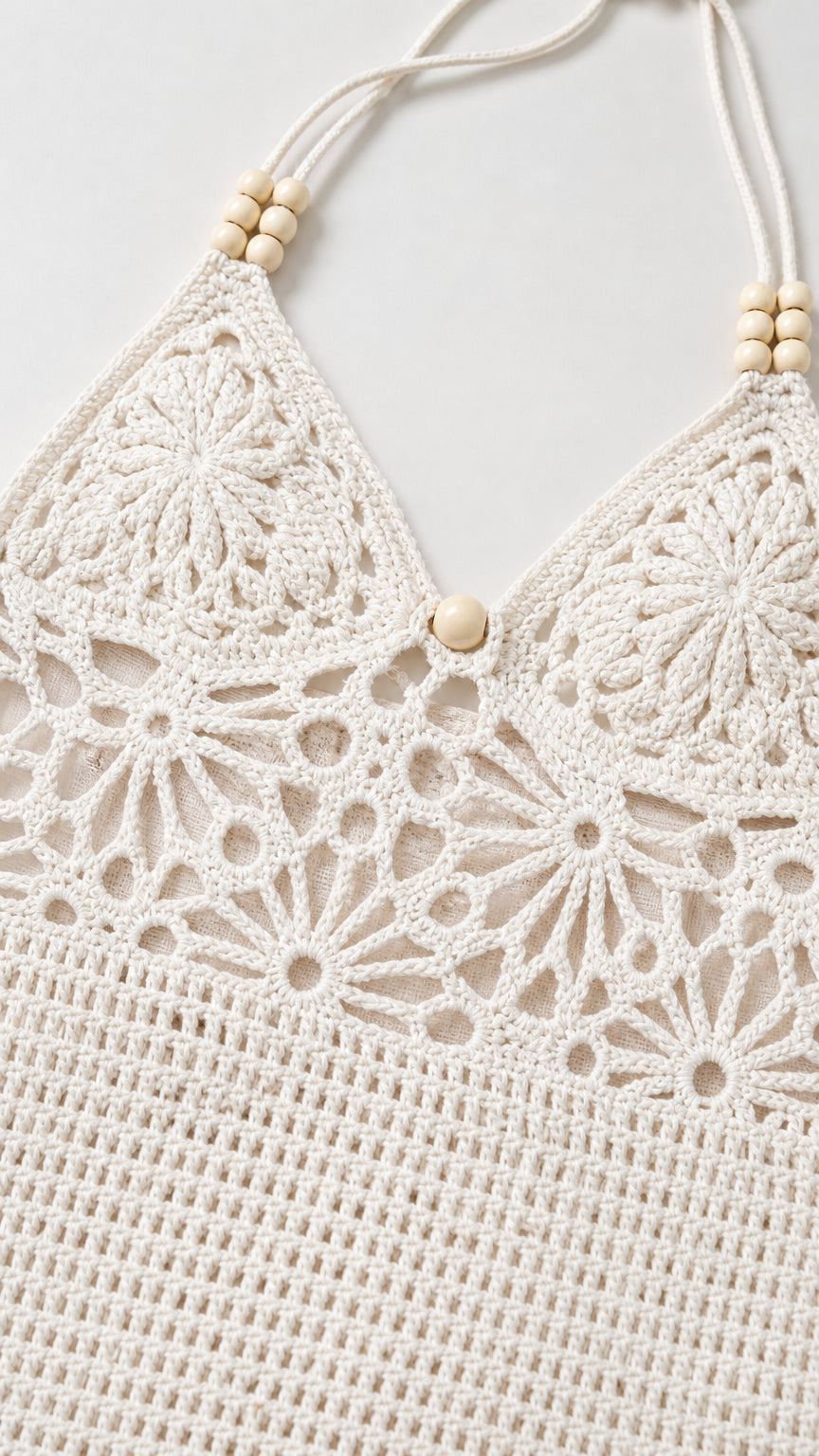 Close-up detail of white crochet halter neckline with wooden beads