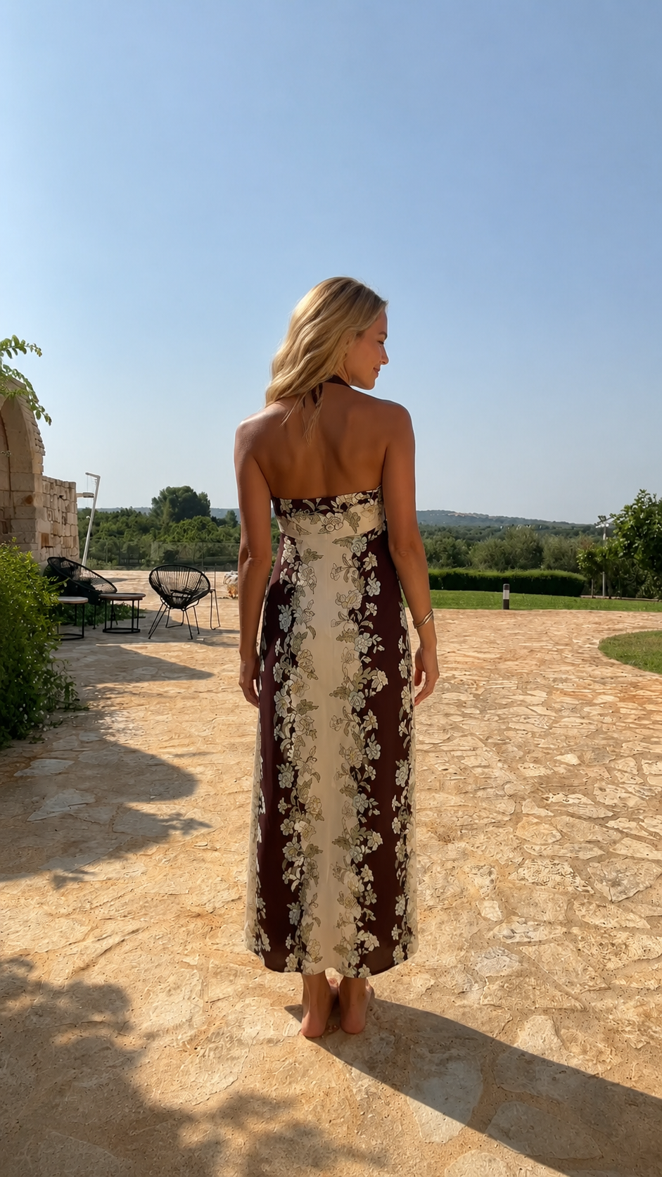 Back view of chocolate and cream floral halter maxi dress with open back detail