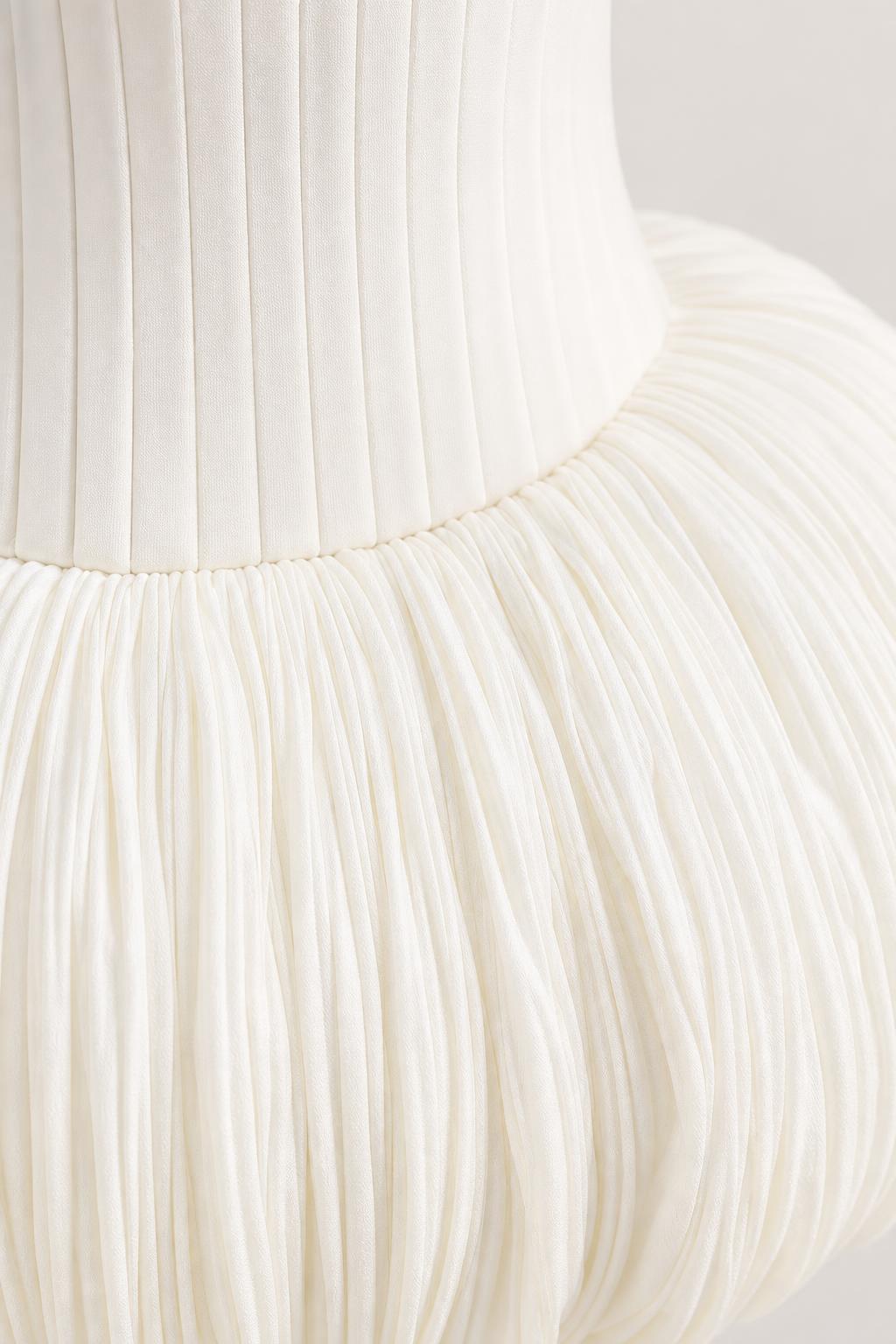 Close-up detail of fine vertical pleats and textured bubble hem