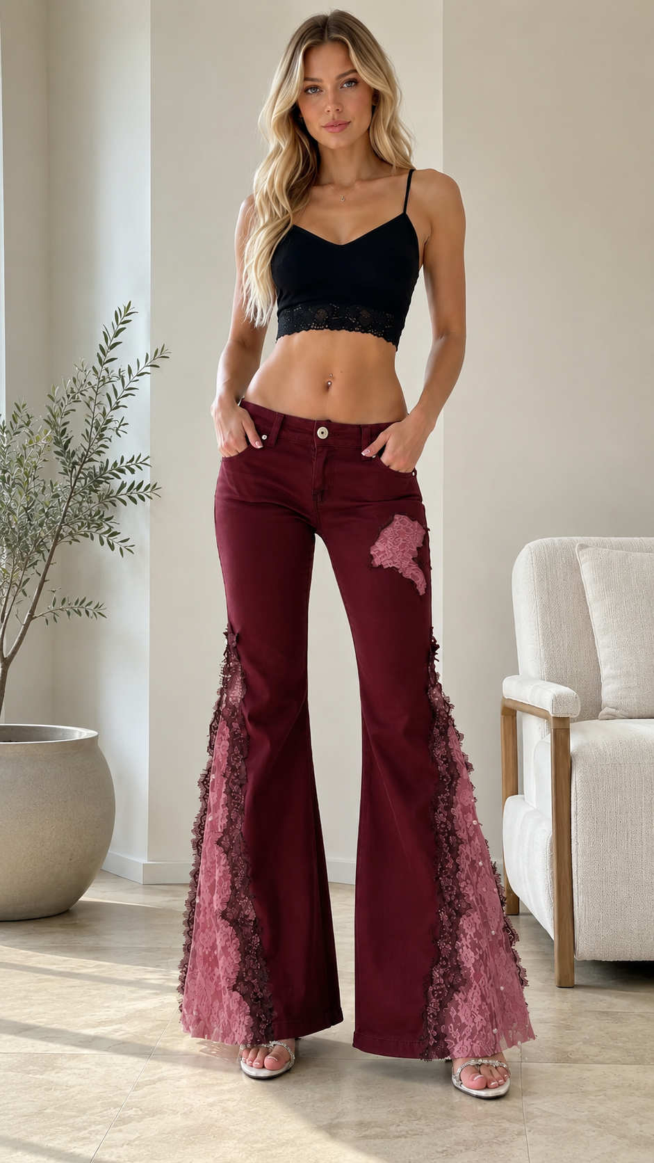 Front view of burgundy flare jeans with pink lace side panels and floral appliqué