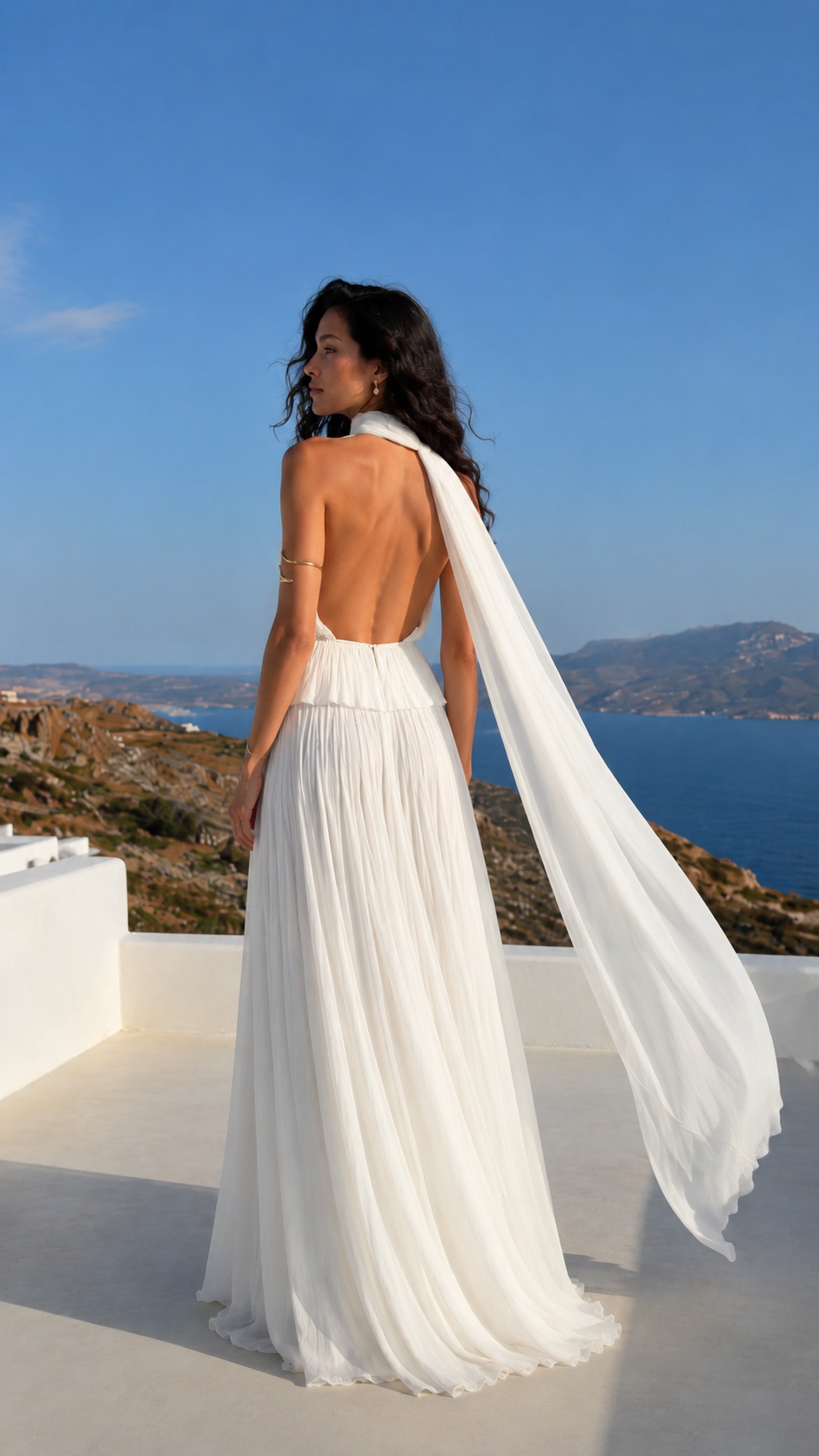 Back view of white pleated halter maxi dress with open back and trailing scarf