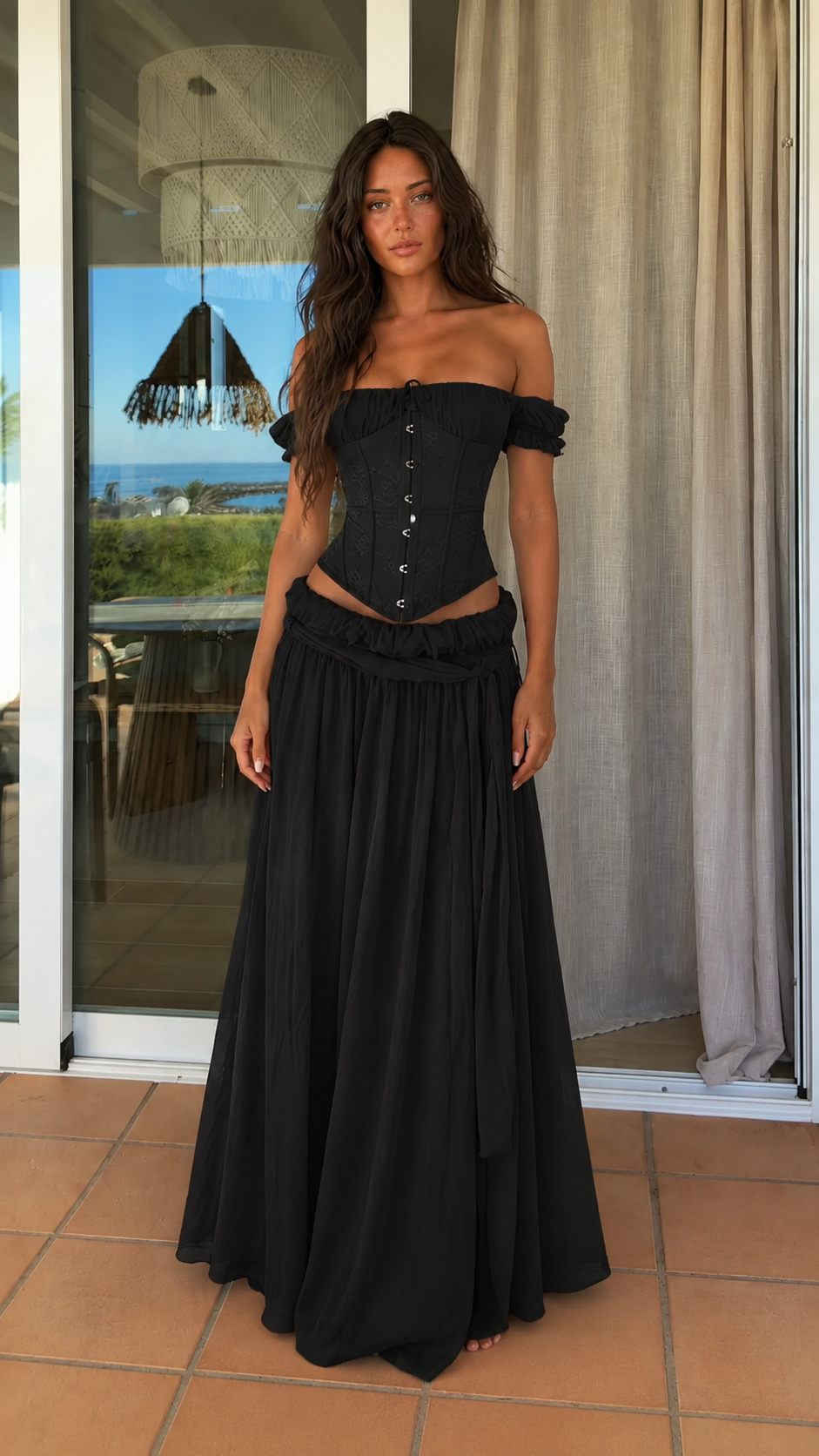 Front view of black off shoulder corset top and maxi skirt set